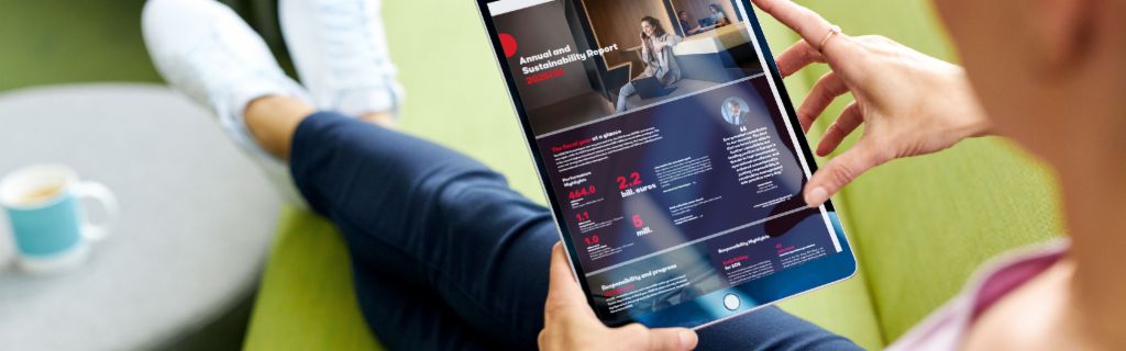 EOS ASR: Obrázok zobrazuje mladú ženu, ktorá drží tablet a pozerá si na ňom Výročnú správu o udržateľnosti EOS.