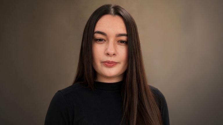 Daniela Moaca, Senior Manager IT v EOS Romania, portrétna fotografia v tmavom rolákovom svetri.