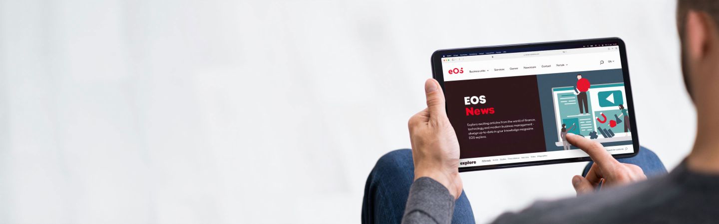 Osoba drží tablet, na ktorom je otvorená webová stránka EOS Newsroom, poskytujúca informácie o najnovších správach, online článkoch a tlačových správach.
