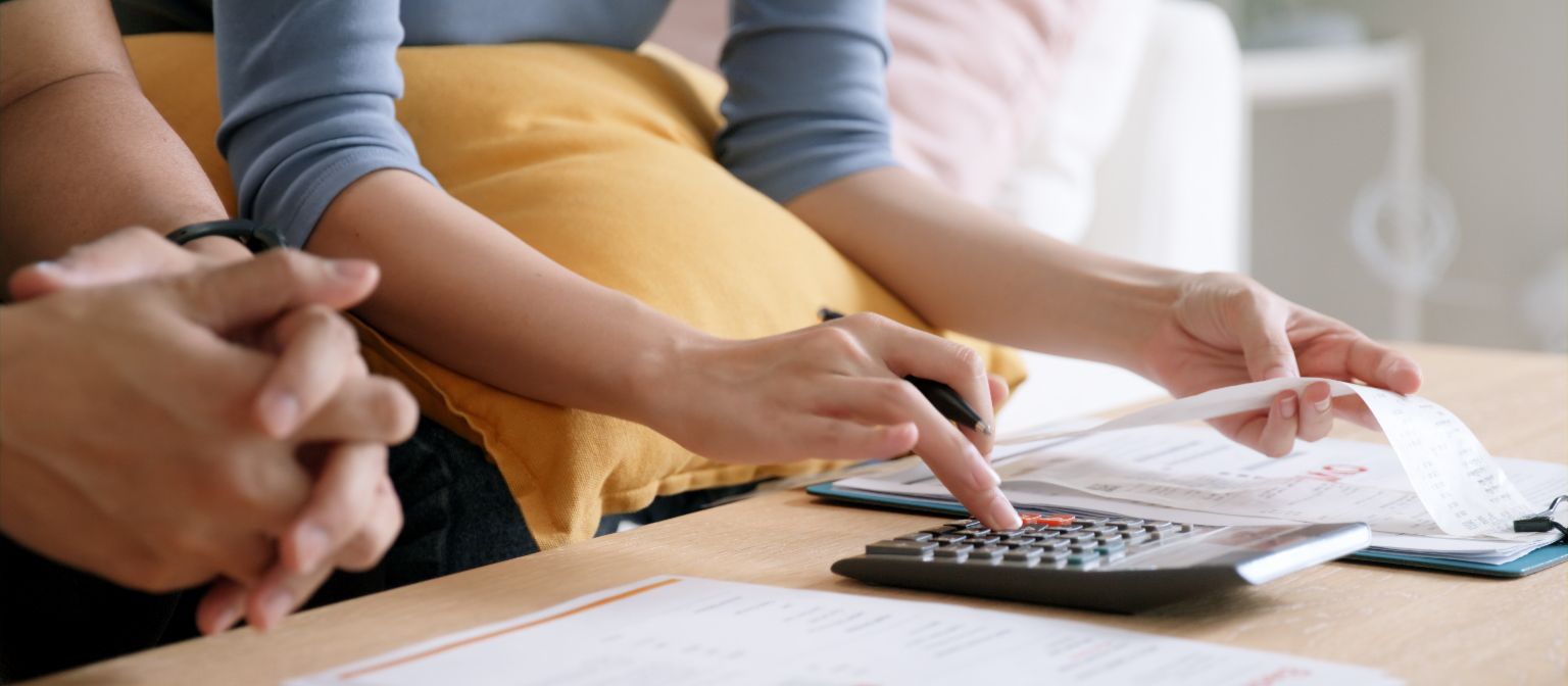 Hands of a woman calculating invoices with a calculator