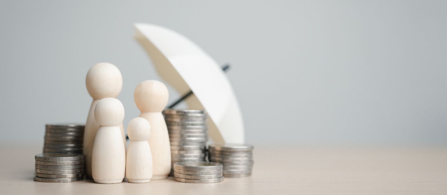 Illustration of four figures standing under an umbrella with stacks of coins around them. 