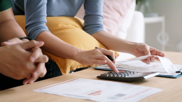 Hands of a woman calculating invoices with a calculator